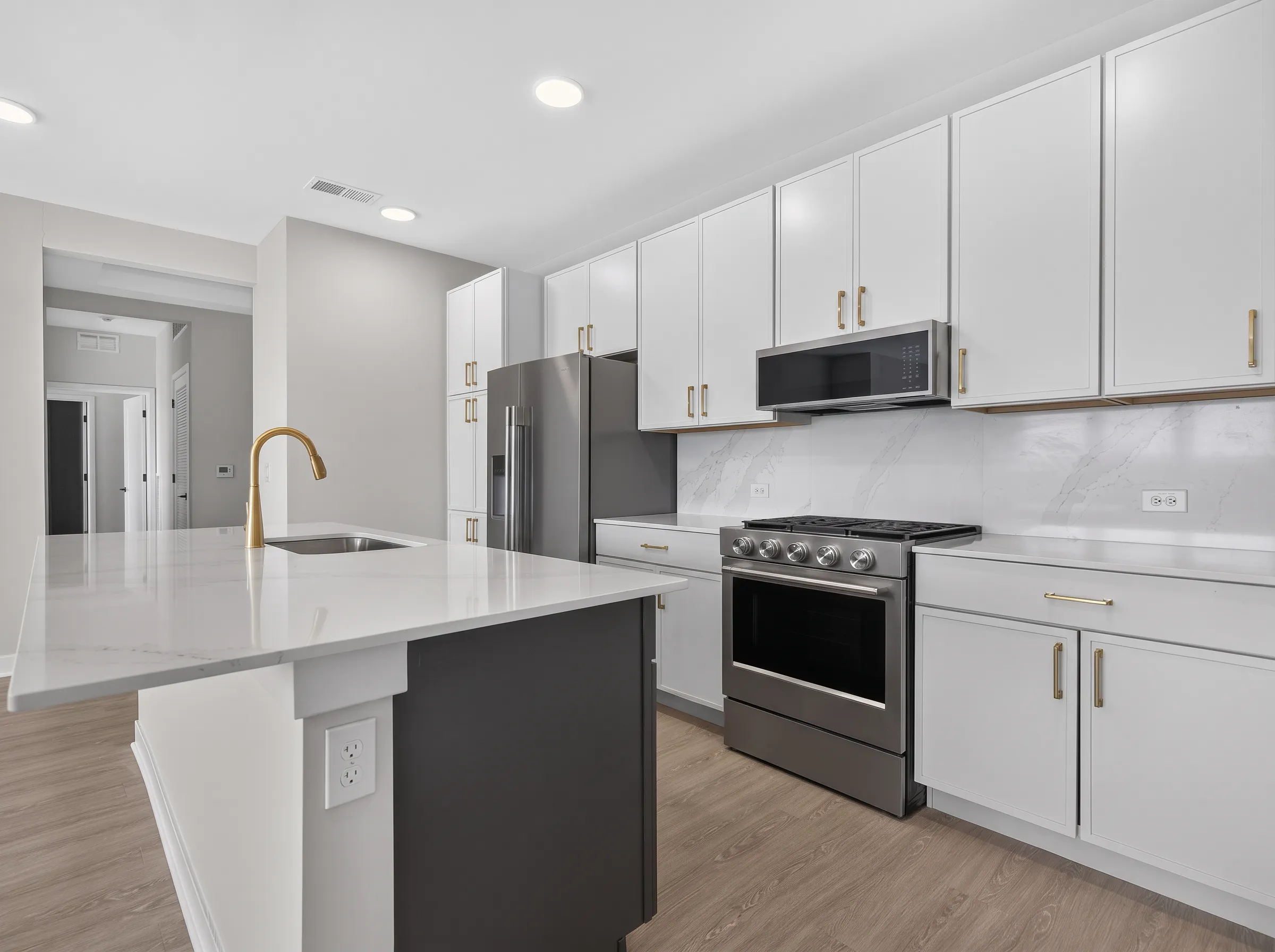Real estate photography of a kitchen with a waterfall island in a penthouse unit shot by Ian K Captures